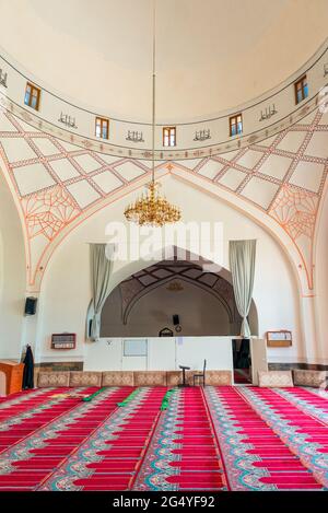 Das Innere einer leeren muslimischen Moschee mit Teppichen auf dem Boden für Gemeindemitglieder Stockfoto