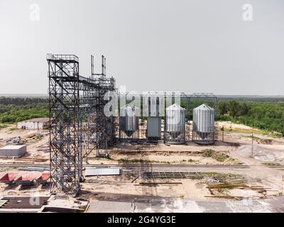 Luftaufnahme des riesigen modernen Getreideaufzugs. Lagerung von Lebensmitteln, Gebäude in Arbeit. Silofarm. Entwicklung der Agrarindustrie. Stockfoto