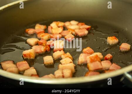 Frischer Speck in Öl in einer Pfanne gebraten Stockfoto