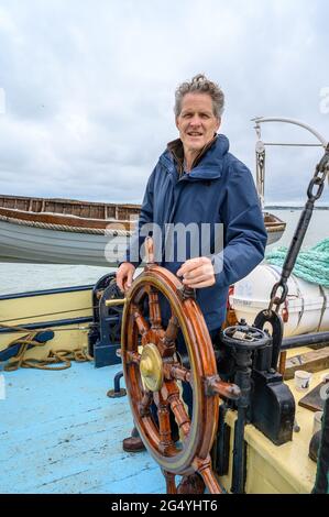 Sichere Hände: Passagier auf dem historischen Segelschiff „Edith May“ als amtierender Skipper auf einer Reise in die Themse-Mündung, Kent, England. Stockfoto