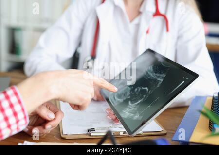 Ärztin zeigt digitale Tablette mit Ultraschall-Bild des Unten in der Klinik Nahaufnahme Stockfoto