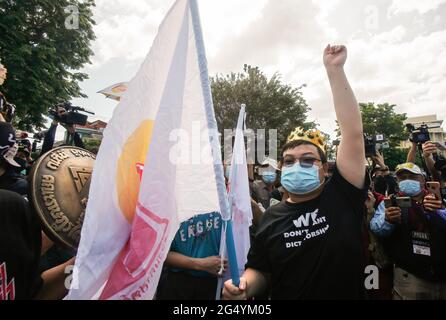 Parit chiwarak (auch bekannt als Penquin), ein prodemokratischer Protestler mit Gesichtsmaske, wird während der Kundgebung für die Demokratie in Bangkok mit einer Fahne und einer Faust gesehen. Hunderte von prodemokratischen Demonstranten versammelten sich heute Morgen vor dem Demokratie-Denkmal in Bangkok, um den 89. Jahrestag der Revolution vom 24. Juni 1932 zu begehen, und marschierten zum parlament, um ihre drei-Punkte-Forderung zu unterstreichen; Der Rücktritt aller 250 vom Militär ernannten Senatoren, der Rücktritt von Premierminister Prayut Chan-o-cha und eine Neufassung der Verfassung. (Foto von Chaiwat Subprasom/SOPA Images/Sipa USA) Stockfoto