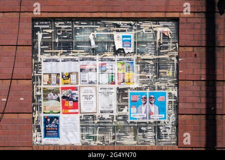 Fenster mit Werbung und Hinweisen, die in erster Linie in Jiddisch sind abgedeckt. In Der Williamsburg Street, Brooklyn, New York. Stockfoto