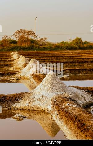 Wunderschöne Aufnahme von Salzverdunstungspeichen vor dem Hintergrund des orangefarbenen Sonnenuntergangs Stockfoto