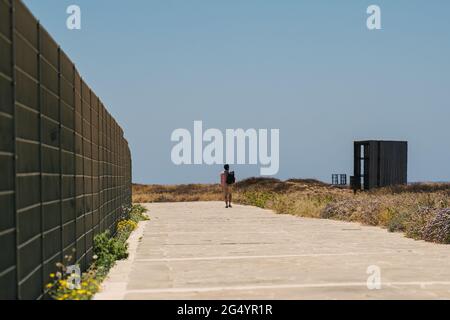 Küstenspaziergang entlang des mittelmeers auf der Insel zypern in der Stadt paphos. Reisende mit Rucksack spazieren entlang des Wanderweges in der Nähe der Küste. Aktiv Stockfoto