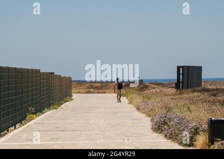 Thema der Erkundung der Insel Zypern zu Fuß. Mann mit Rucksack ist Spaziergänge am Meer entlang der Küste Broadwalk in der Stadt Paphos auf Zypern im Sommer Stockfoto