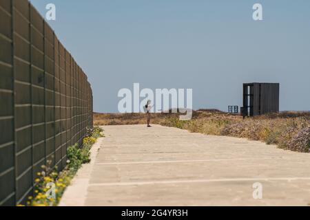 Thema der Erkundung der Insel Zypern zu Fuß. Mann mit Rucksack ist Spaziergänge am Meer entlang der Küste Broadwalk in der Stadt Paphos auf Zypern im Sommer Stockfoto