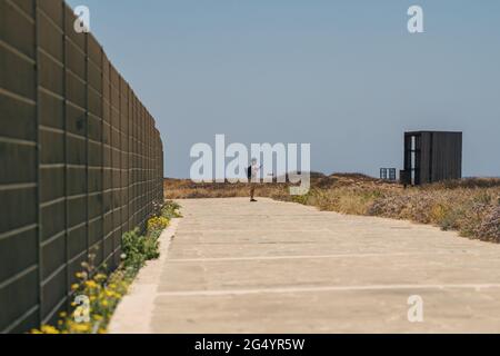 Küstenspaziergang entlang des mittelmeers auf der Insel zypern in der Stadt paphos. Reisende mit Rucksack spazieren entlang des Wanderweges in der Nähe der Küste. Aktiv Stockfoto