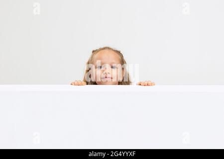 Portrait von schönen kleinen Mädchen in legerer Kleidung isoliert auf weißem Studio-Hintergrund. Happy Childhood Konzept. Stockfoto