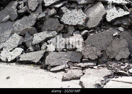 Gebrochener Asphalt. Teile einer asphaltierten Straße. Gebrochene Oberflächenstruktur der Straße. Gesprungener Asphaltstapel. Demontage der Autobahn. Stockfoto