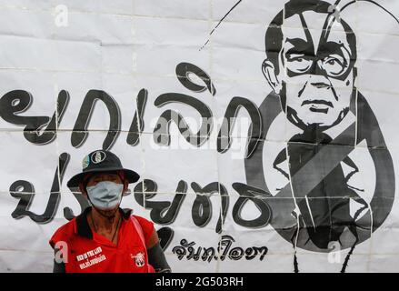 Ein prodemokratischer Protestler der Gruppe United People for Thailand (UPT) mit Gesichtsmaske steht während einer prodemokratischen Kundgebung vor einem Banner, um zu demonstrieren, dass der thailändische Premierminister Prayuth Chan O-Cha in Bangkok zum Rücktritt aufgefordert wird. (Das Wort lautet Abbrechen Prayuth Chan O-Cha). (Foto von Chaiwat Subprasom / SOPA Images/Sipa USA) Stockfoto