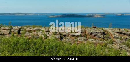 Panorama der Meereslandschaft mit Felsen und Felsbrocken im Vordergrund. Weißes Meer, Russland, Blick auf den Archipel von Kusova von einem Höhepunkt. Inseln, Meer, Himmel und Stockfoto