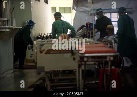 Jakarta, Indonesien. Juni 2021. Medizinische Fachkräfte, die Schutzanzüge tragen, verlegen einen COVID-19-Patienten auf die Intensivstation eines Krankenhauses in Jakarta, Indonesien, 24. Juni 2021. Quelle: Agung Kuncahya B./Xinhua/Alamy Live News Stockfoto