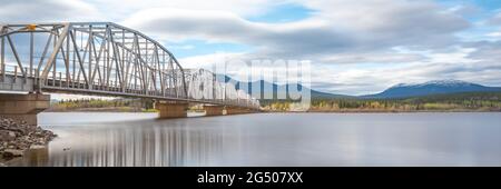 Große, von Menschen hergestellte Stahlbrücke über die Nisutlin Bay in der Gemeinde Teslin, die im Frühjahr zum Yukon River im Norden Kanadas fließt. Stockfoto