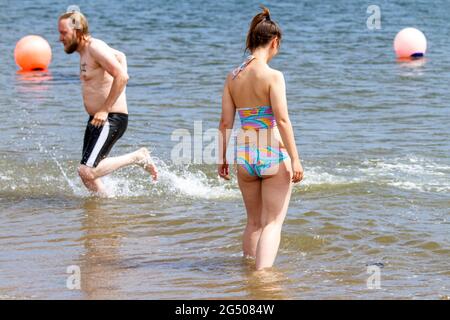 Dundee, Tayside, Schottland, Großbritannien. Juni 2021. UK Wetter: Ein sonniger und warmer Tag mit einer kühlen westlichen Brise durch Nordostschottland mit Temperaturen bis zu 19 Grad Ein junges Paar Sofie Wilcox und Andrew Smith verbringen Zeit zusammen, um die Sonne zu genießen, während sie Spaß am Fluss Tay am Broughty Ferry Beach in Dundee haben. Kredit: Dundee Photographics/Alamy Live Nachrichten Stockfoto