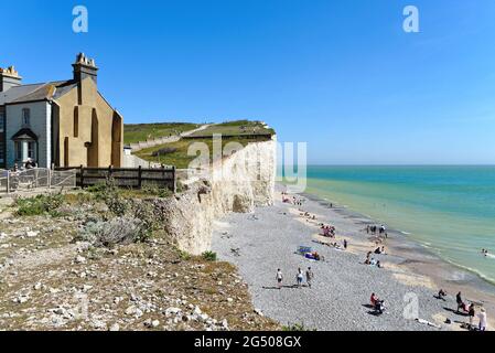 Die instabile Kreide-Klippe von Birling Gap mit alten Hütten am Klippenrand und am Strand unten an einem Sommertag, Eastbourne East Sussex England, Großbritannien Stockfoto