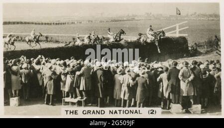 ‘Heimatveranstaltungen’ W.D. UND H.O. Tests Zigarettenkarte mit dem Titel „The Grand National (2)“. „das Foto zeigt, wie die Menge die Pferde am Becher's Brook beim zweiten Mal während der Grand National Steeplechase in Aintree, Liverpool, beobachtet. Der Kurs ist 4 1/2 Meilen lang und umfasst 30 Sprünge. ‘den Tagen seiner Gründung war die Jagd nach dem „Kirchturm“ nur ein Rennen von einem Kirchturm zum anderen und zurück.“ Veröffentlicht im Jahr 1932. Stockfoto