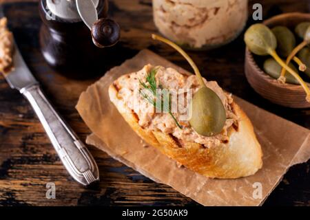 Sandwich mit Hähnchenpastete mit Kaper auf einem dunklen alten Brett Hintergrund. Selektiver Fokus. Stockfoto