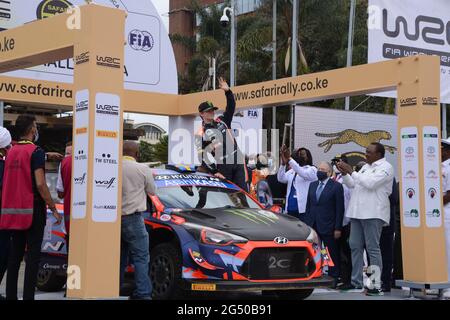 Nairobi, Kenia. Juni 2021. Der norwegische Fahrer Oliver Solberg winkt von seinem Auto aus der Menge zu, während Kenias Präsident Uhuru Kenyatta und der Präsident der FIA (Fédération Internationale de l'Automobile) Jean Todt während der offiziellen Zeremonie zur Flaggenabsetzung der World Rally Championship (WRC)-Safaryallye 2021 auf dem KICC-Gelände in Nairobi aufblicken. Die Safari-Rallye feiert nach 19 Jahren Pause ein Comeback. Kredit: SOPA Images Limited/Alamy Live Nachrichten Stockfoto