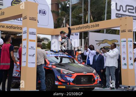 Nairobi, Kenia. Juni 2021. Der norwegische Fahrer Oliver Solberg winkt von seinem Auto aus der Menge zu, während Kenias Präsident Uhuru Kenyatta und der Präsident der FIA (Fédération Internationale de l'Automobile) Jean Todt während der offiziellen Zeremonie zur Flaggenabsetzung der World Rally Championship (WRC)-Safaryallye 2021 auf dem KICC-Gelände in Nairobi aufblicken. Die Safari-Rallye feiert nach 19 Jahren Pause ein Comeback. (Foto von Dennis Sigwe/SOPA Images/Sipa USA) Quelle: SIPA USA/Alamy Live News Stockfoto