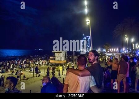 Barcelona, Spanien. Juni 2021. Die Leute sahen das Feuerwerk am Barceloneta Strand. Eines der traditionellsten Feste in Katalonien, die Johannisnacht, die in der Nacht vom 23. Auf den 24. Juni gefeiert wird, bei der das Abfeuern von Feuerwerkskörpern und Feuerwerkskörpern traditionell ist, kehrt zurück, nachdem 2020 nicht zur Feier der Coronavirus-Pandemie zugelassen wurde. (Foto von Thiago Prudencio/SOPA Images/Sipa USA) Quelle: SIPA USA/Alamy Live News Stockfoto