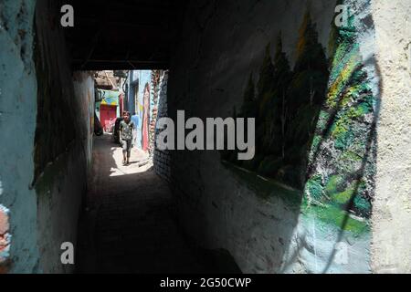 Bagdad, Irak. Juni 2021. Ein Junge kommt am 2. Juni 2021 an Wandmalereien im alten al-Anbariyen-Slum in Bagdad, Irak, vorbei. ZUM THEMA „Feature: Maler holen freiwillig neues Leben in die alte Nachbarschaft Bagdads“ Credit: Khalil Dawood/Xinhua/Alamy Live News Stockfoto