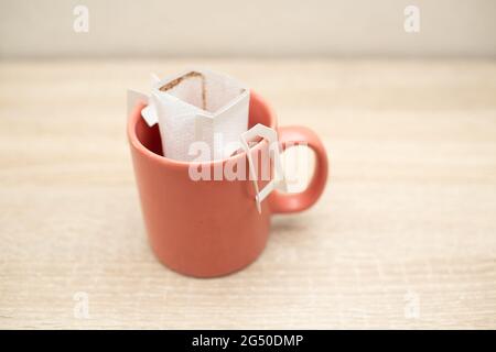 Kaffee tropft in die Tasse. Alternativer Kaffee für die Zubereitung von Spezialkaffee in Papierfiltertüten. Stockfoto