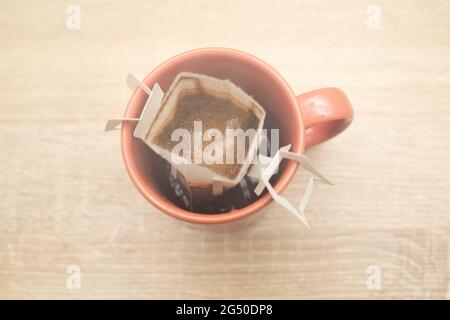Kaffee tropft in die Tasse. Alternativer Kaffee für die Zubereitung von Spezialkaffee in Papierfiltertüten. Stockfoto