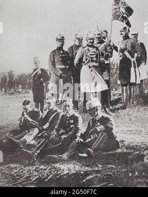 Der deutsche kaiser Wilhelm II. Und seine Mitarbeiter. Zu seinen Füßen, seinem Sohn, dem kronprinz Friedrich Wilhelm, hat die Zigarette den Mund. 1914 Stockfoto