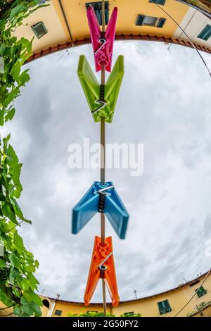 Farbige Wäscheklammern hängen an einem Faden Stockfoto