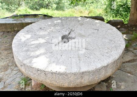 Granitstein im französischen Stil aus einer Getreidemühle. Als Tisch auf einem Platz in einer Stadt in Spanien aufgestellt. Stockfoto