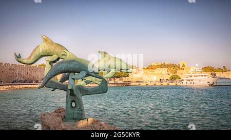 RHODOS, GRIECHENLAND - 06. OKTOBER 2018: Die Delfinskulptur im Hafen von Mandraki. Stockfoto