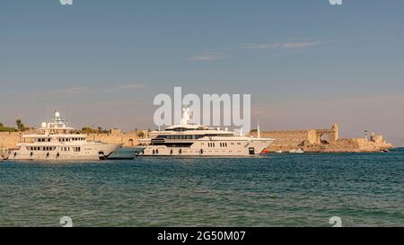 RHODOS, GRIECHENLAND - 06. OKTOBER 2018: Mandraki Hafen auf Rhodos mit Yachten, Linienschiffen und Booten voller Touristen Stockfoto