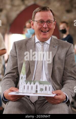 Ellrich, Deutschland. Juni 2021. In der Johanniskirche sitzt der thüringische Ministerpräsident Bodo Ramelow (die Linke) mit einem Kirchenmodell. Für den Wiederaufbau des Glockenturms übergab der Ministerpräsident von Thüringen am selben Tag einen Zuschussscheck in Höhe von 3.1 Millionen Euro. Der Glockenturm soll bis 2024 errichtet werden. Der alte Turm wurde Anfang des 20. Jahrhunderts einem Blitzschlag zum Opfer gefallen. Es wurde wieder aufgebaut, musste aber zu DDR-Zeiten wegen Verfall abgerissen werden. Quelle: Matthias Bein/dpa-Zentralbild/ZB/dpa/Alamy Live News Stockfoto