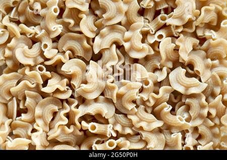 Trockene Vollkorn-Makkaroni-Pasta im Vollformat, Draufsicht. Stockfoto