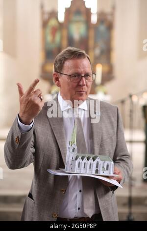 Ellrich, Deutschland. Juni 2021. Der Ministerpräsident Thüringens, Bodo Ramelow (die Linke), erhält ein Modell der Johanniskirche. Für den Wiederaufbau des Glockenturms überreichte der Ministerpräsident von Thüringen am selben Tag einen Zuschussscheck in Höhe von 3.1 Millionen Euro. Der Glockenturm soll bis 2024 errichtet werden. Der alte Turm wurde Anfang des 20. Jahrhunderts einem Blitzschlag zum Opfer gefallen. Es wurde wieder aufgebaut, musste aber zu DDR-Zeiten wegen Verfall abgerissen werden. Quelle: Matthias Bein/dpa-Zentralbild/ZB/dpa/Alamy Live News Stockfoto