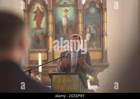 Ellrich, Deutschland. Juni 2021. Der Ministerpräsident Thüringens, Bodo Ramelow (die Linke), spricht in der St. Johannis-Kirche. Blick auf die St. Johannis Kirche. Für den Wiederaufbau des Glockenturms übergab der Ministerpräsident von Thüringen am selben Tag einen Zuschussscheck in Höhe von 3.1 Millionen Euro. Der Glockenturm soll bis 2024 errichtet werden. Der alte Turm wurde Anfang des 20. Jahrhunderts einem Blitzschlag zum Opfer gefallen. Es wurde wieder aufgebaut, musste aber zu DDR-Zeiten wegen Verfall abgerissen werden. Quelle: Matthias Bein/dpa-Zentralbild/ZB/dpa/Alamy Live News Stockfoto