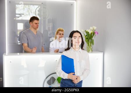 Ein junges hübsches Mädchen kam in die Klinik und sprach mit Ärzten an der Rezeption Stockfoto