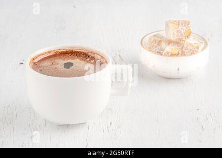 Tasse Kaffee und türkischer Genuss auf einem Holztisch mit Kopierfläche Stockfoto