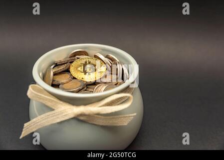 Die Bitcoin-Münze liegt im Sparschwein auf fiat-Münzen. Akkumulation von Kryptowährungen und Investitionssymbol. Speicherplatz kopieren Stockfoto