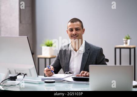 Behinderter Buchhalter Im Rollstuhl, Der Mit Dem Computer Arbeitet Stockfoto