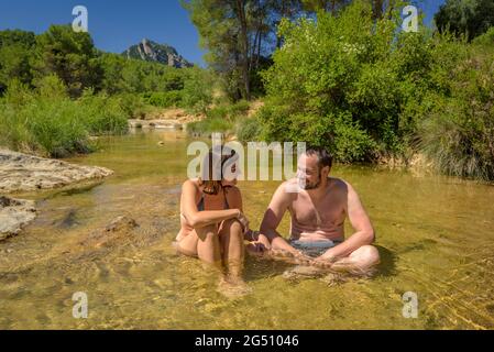 Pärchen, die ein Bad im Naturpool Olles am Fluss Canaletes genießen, Horta de Sant Joan (Terra Alta, Tarragona, Katalonien, Spanien) Stockfoto