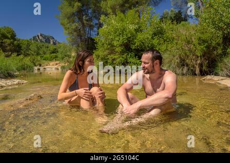 Pärchen, die ein Bad im Naturpool Olles am Fluss Canaletes genießen, Horta de Sant Joan (Terra Alta, Tarragona, Katalonien, Spanien) Stockfoto