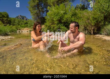 Pärchen, die ein Bad im Naturpool Olles am Fluss Canaletes genießen, Horta de Sant Joan (Terra Alta, Tarragona, Katalonien, Spanien) Stockfoto