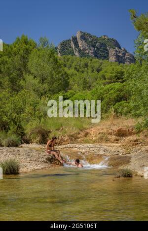 Pärchen, die ein Bad im Naturpool Olles am Fluss Canaletes genießen, Horta de Sant Joan (Terra Alta, Tarragona, Katalonien, Spanien) Stockfoto