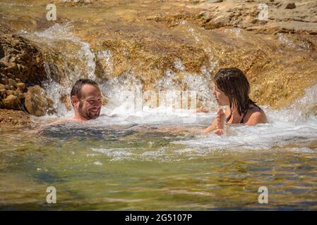 Pärchen, die ein Bad im Naturpool Olles am Fluss Canaletes genießen, Horta de Sant Joan (Terra Alta, Tarragona, Katalonien, Spanien) Stockfoto