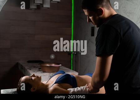 Türkische Schaummassage und Peeling mit Kese-Handschuh. Entspannung im Spa-Center. Masseur macht Massage Stockfoto