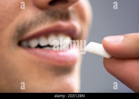 Mann, Der Nikotin-Gum Verwendet, Um Das Rauchen Zu Beenden. Nikotinersatztherapie Stockfoto