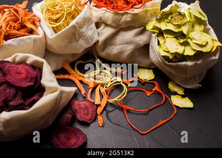 Dehydriertes Gemüse in Textilbeuteln auf Schwarz Stockfoto