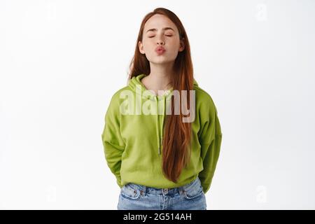 Porträt von niedlichen und albern Mädchen mit roten Haaren warten auf Kuss, nahe Augenlippen und Pucker Lippen, küssen jemand, Gefühl romantisch, über weiß stehen Stockfoto